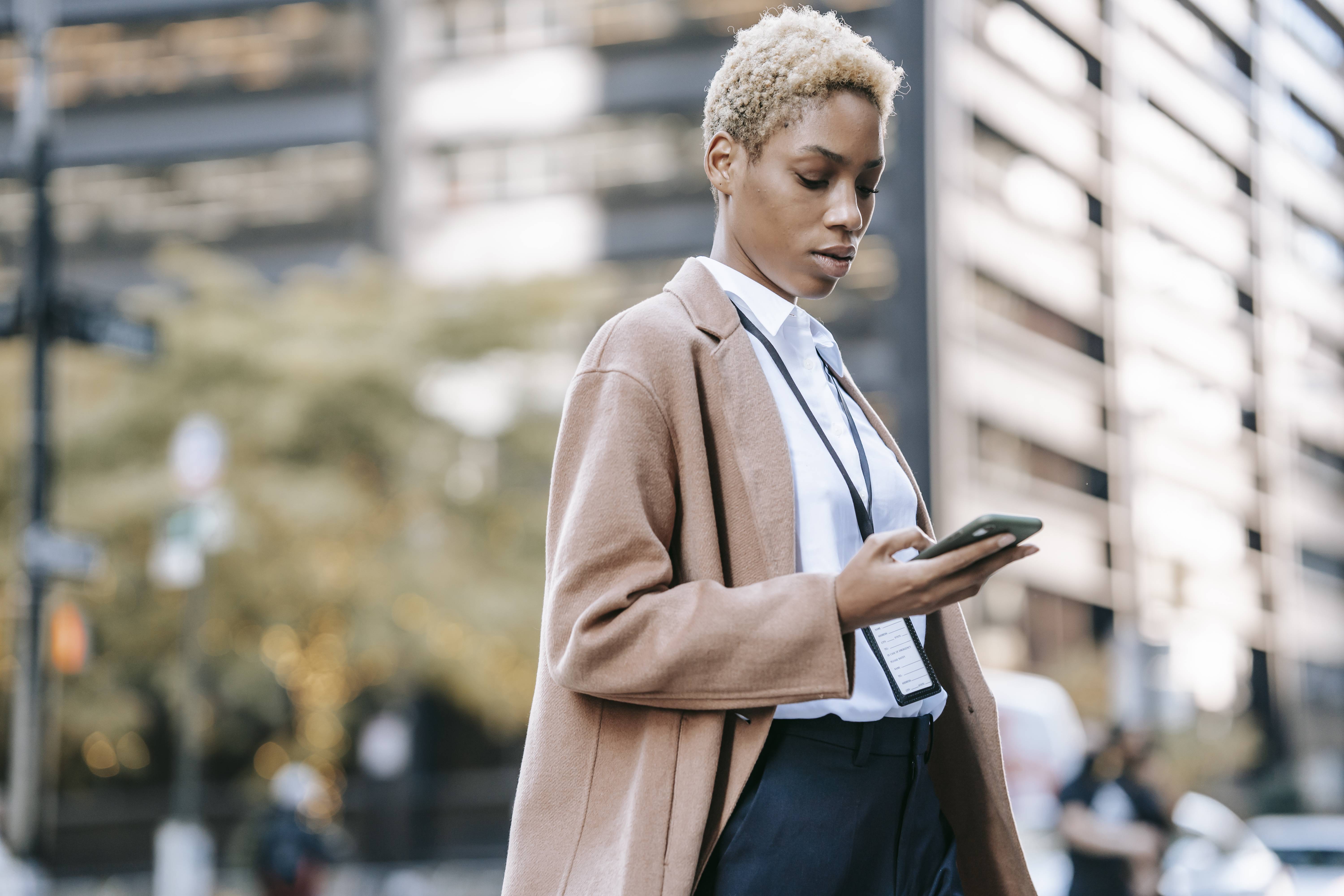 Woman walking in the city looking at her phone