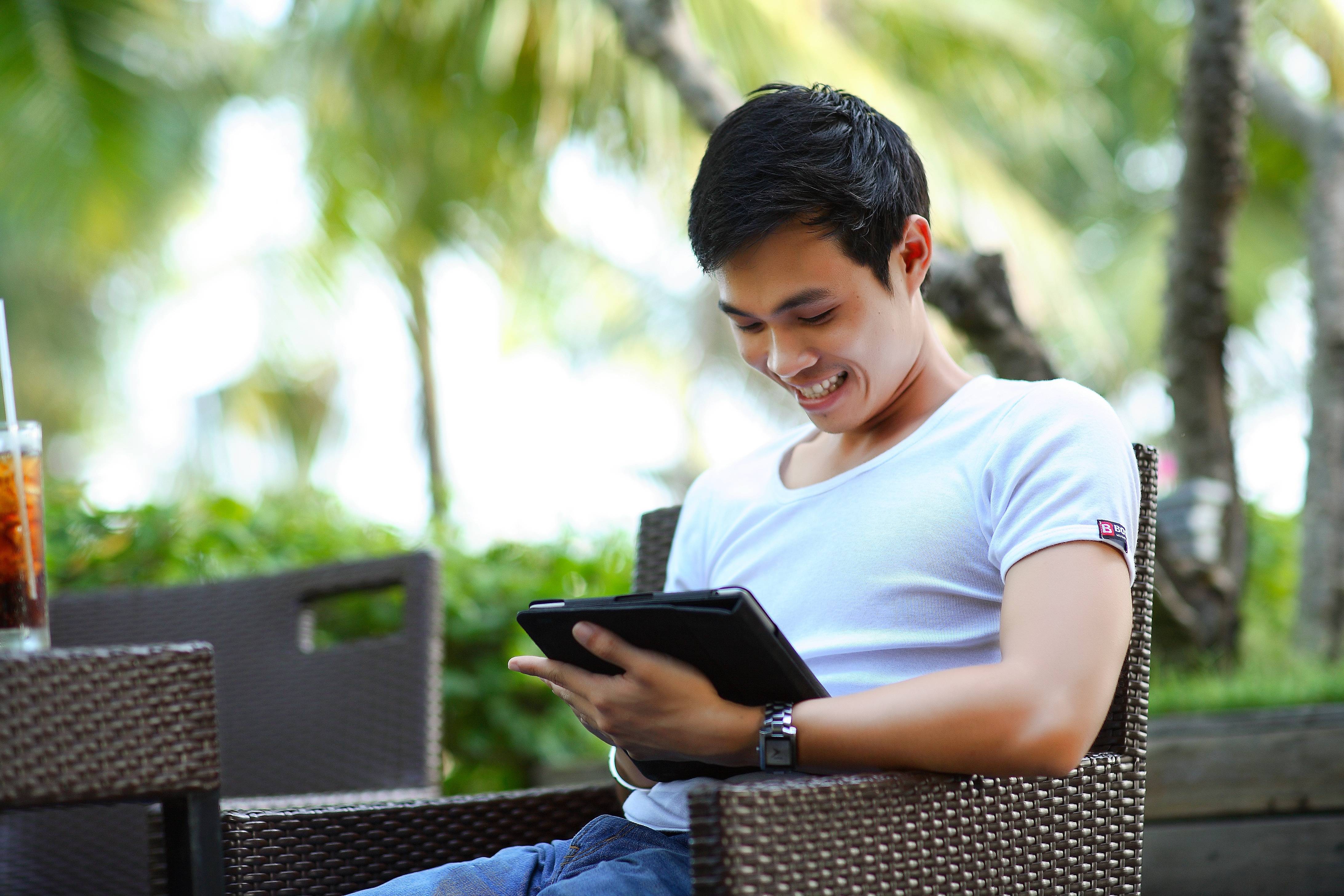 Man sitting outside looking at his tablet